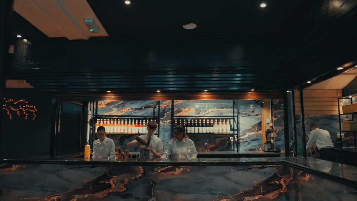 The bar at The Bastian with marble counter and bottles on display