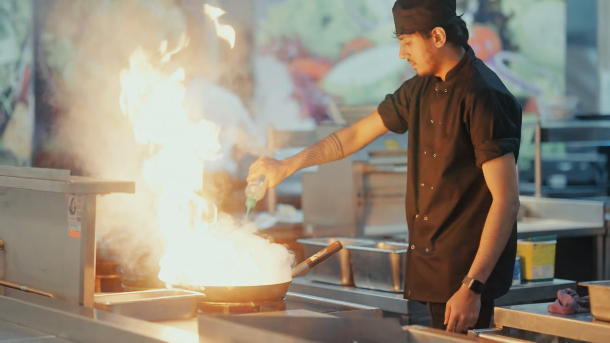 Chef cooking with flames in the wok