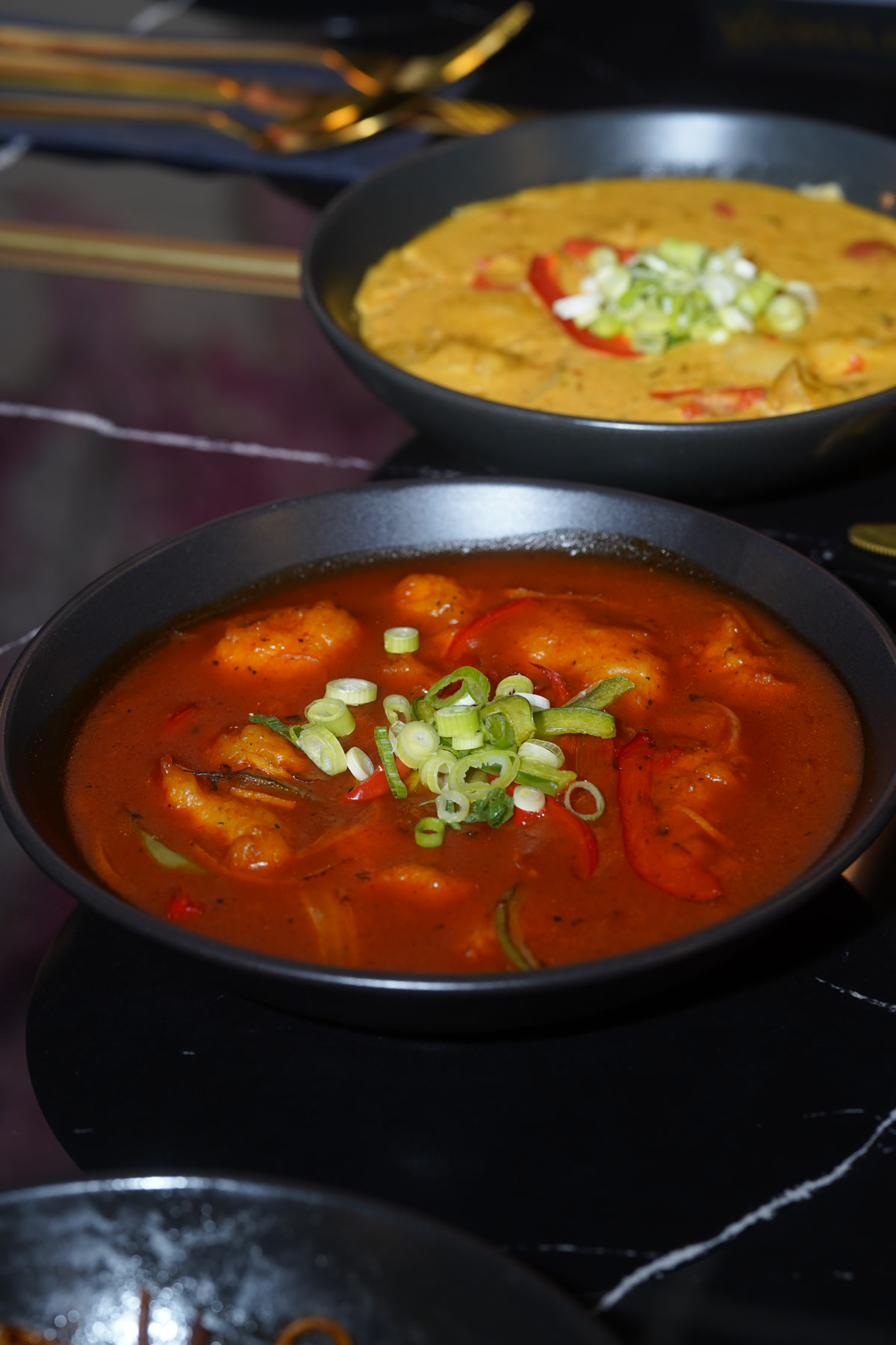 Two signature curries close-up: red prawn and yellow karahi